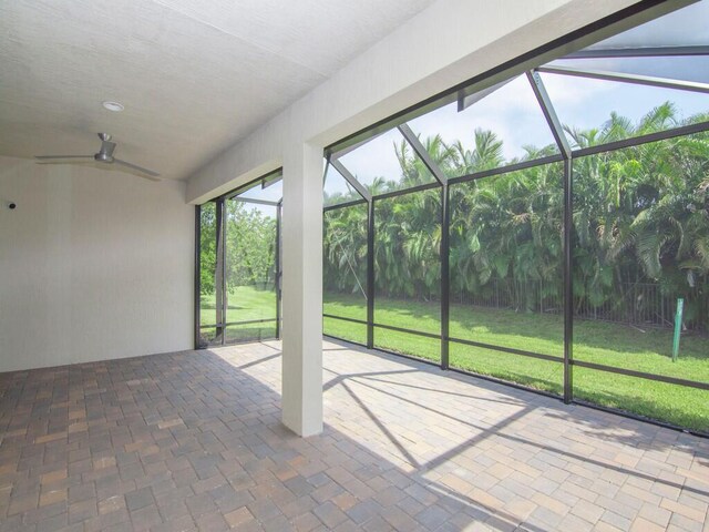 unfurnished sunroom with ceiling fan