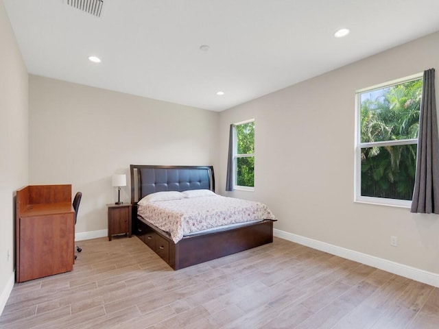 bedroom featuring multiple windows and light hardwood / wood-style flooring