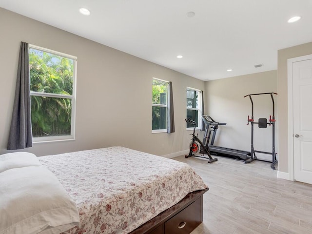 bedroom with light hardwood / wood-style floors and multiple windows