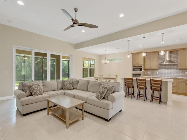 living room featuring light tile patterned floors and ceiling fan with notable chandelier