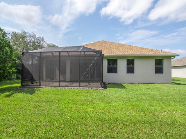 back of house with a yard and a lanai