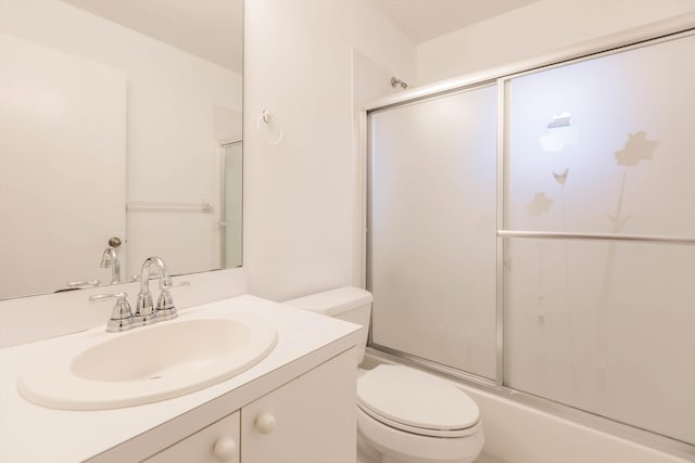 full bathroom featuring bath / shower combo with glass door, vanity, and toilet