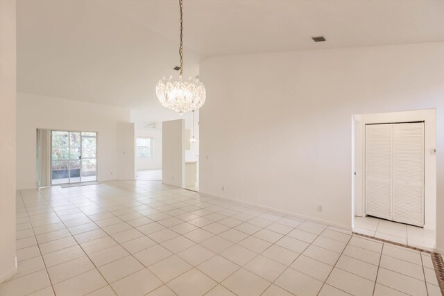 empty room with a chandelier and light tile patterned floors