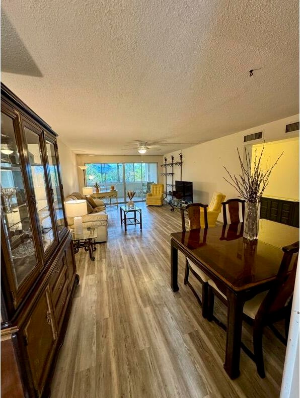 dining area with hardwood / wood-style floors and a textured ceiling