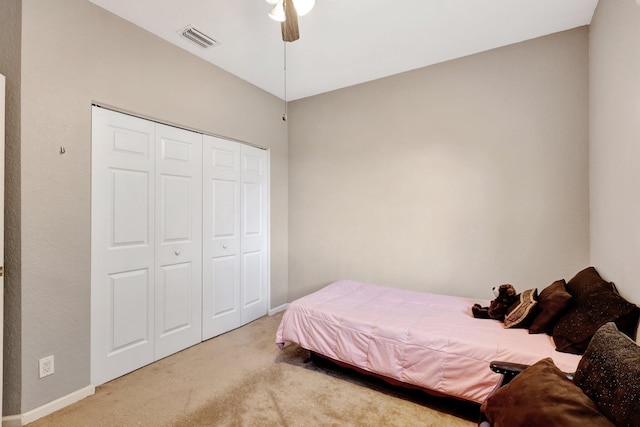 carpeted bedroom with a closet, vaulted ceiling, and ceiling fan