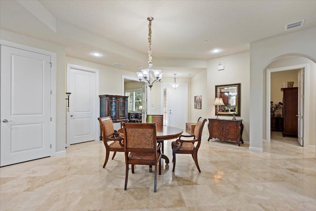 dining room with a chandelier and a textured ceiling