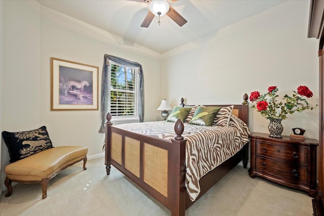 bedroom with ceiling fan, light colored carpet, and a textured ceiling