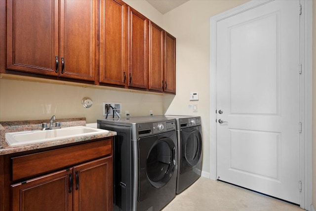 laundry room featuring washing machine and dryer, sink, and cabinets