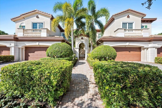 mediterranean / spanish house featuring a balcony and a garage