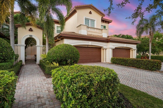 mediterranean / spanish-style house with a balcony and a garage