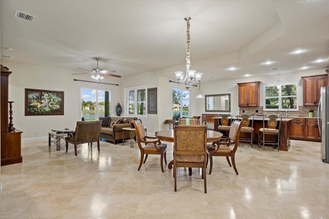 dining space featuring plenty of natural light and ceiling fan with notable chandelier