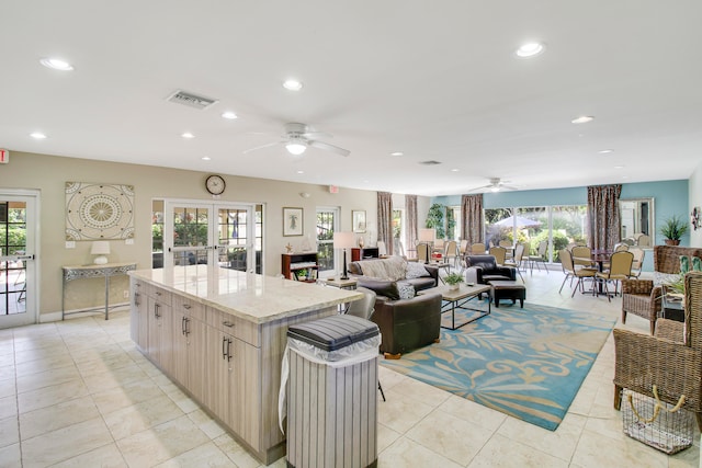 kitchen featuring a wealth of natural light, a center island, and light brown cabinets