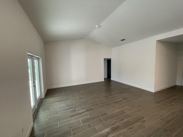 unfurnished room featuring lofted ceiling and dark wood-type flooring