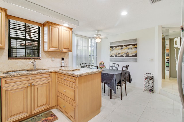 kitchen with sink, decorative backsplash, ceiling fan, light tile patterned floors, and kitchen peninsula