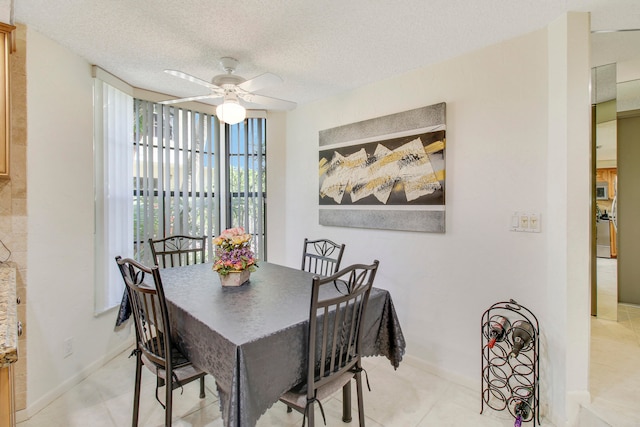 tiled dining room featuring a textured ceiling and ceiling fan