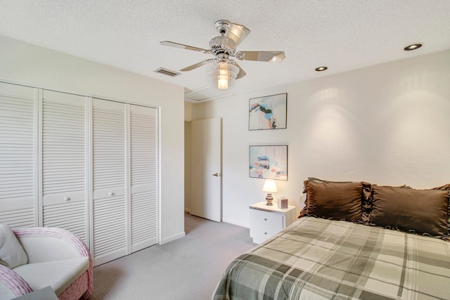 bedroom with ceiling fan, light colored carpet, a textured ceiling, and a closet