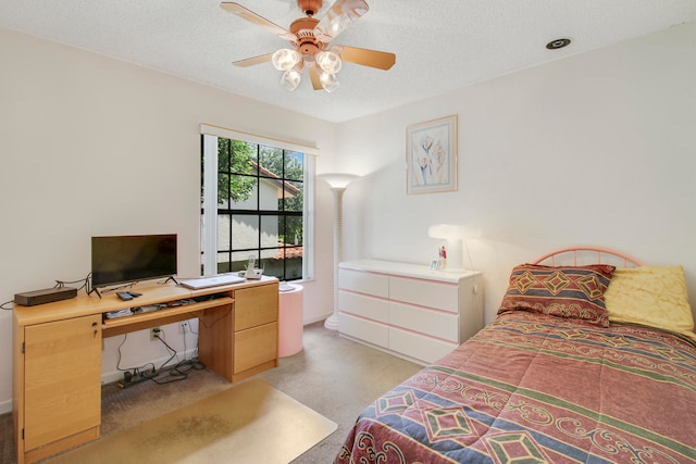 bedroom with ceiling fan, light colored carpet, and a textured ceiling