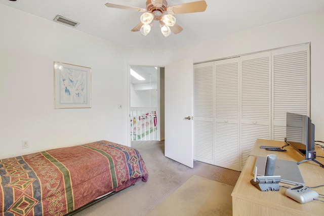 carpeted bedroom with ceiling fan and a closet