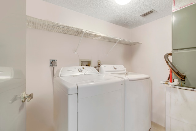 washroom featuring washing machine and dryer and a textured ceiling