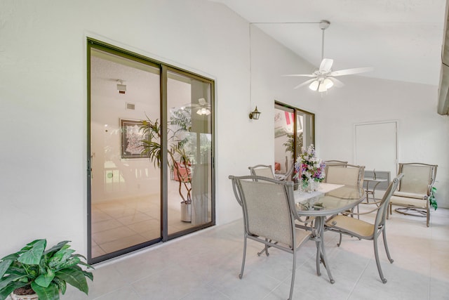 tiled dining room with ceiling fan and lofted ceiling