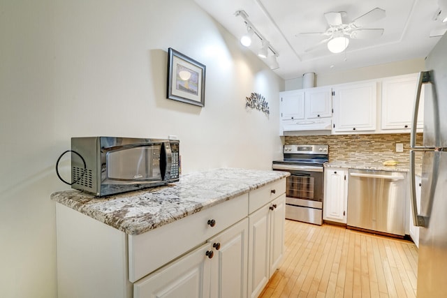 kitchen featuring decorative backsplash, light wood-type flooring, light stone counters, stainless steel appliances, and white cabinetry