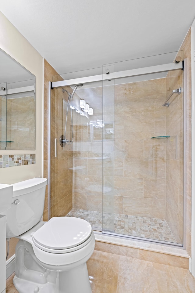 bathroom featuring a shower with door, tile patterned flooring, and toilet