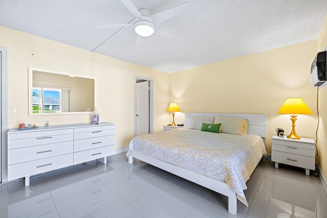 bedroom with a textured ceiling, ceiling fan, and light tile patterned flooring