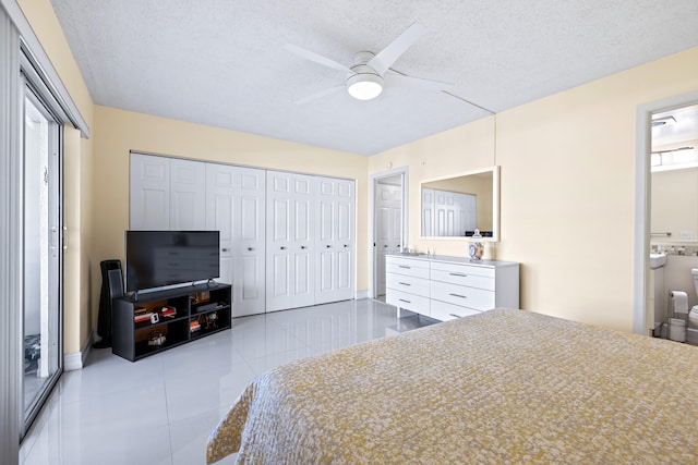 tiled bedroom with multiple windows, a textured ceiling, connected bathroom, and ceiling fan