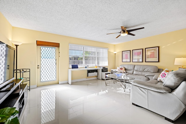 living room with a textured ceiling, ceiling fan, and light tile patterned flooring