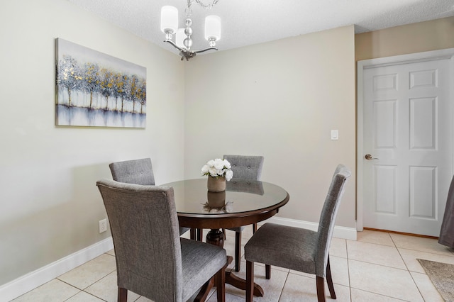 tiled dining space featuring a textured ceiling and an inviting chandelier