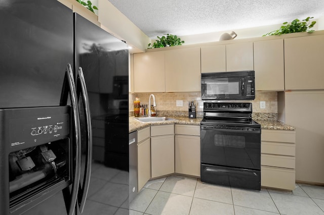 kitchen featuring cream cabinets, sink, and black appliances