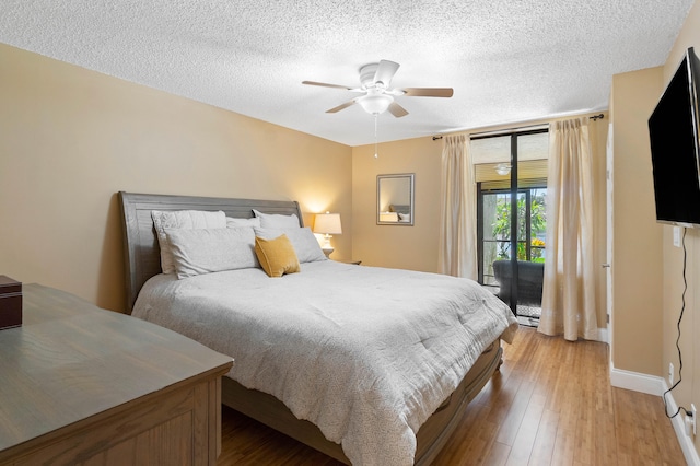 bedroom featuring ceiling fan, access to exterior, light wood-type flooring, and a textured ceiling