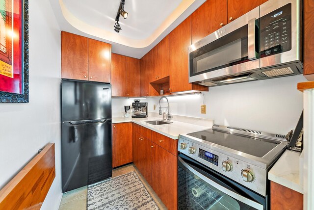 kitchen with sink, light tile patterned floors, stainless steel appliances, and track lighting