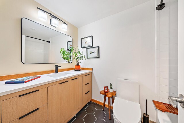 bathroom with toilet, vanity, and tile patterned floors