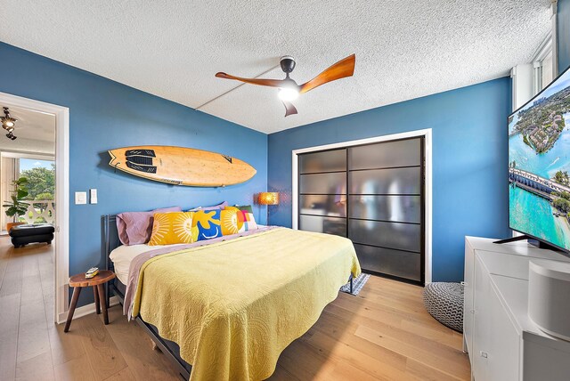 bedroom featuring ceiling fan, light hardwood / wood-style floors, and a textured ceiling