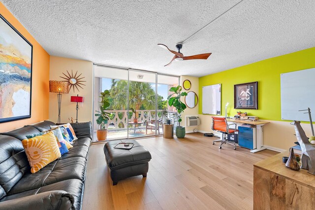 living room featuring a textured ceiling, light hardwood / wood-style flooring, floor to ceiling windows, and ceiling fan