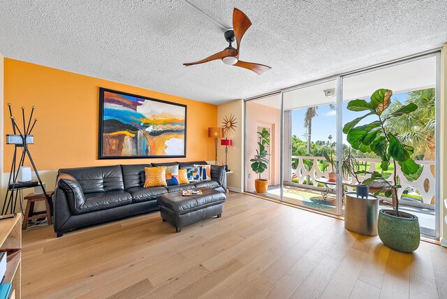 living room featuring a textured ceiling, light hardwood / wood-style floors, floor to ceiling windows, and ceiling fan