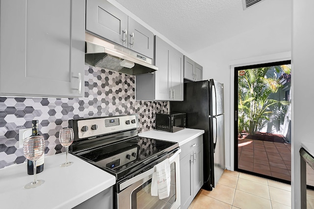 kitchen featuring gray cabinetry, tasteful backsplash, a textured ceiling, light tile patterned flooring, and black appliances