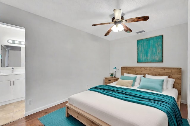 bedroom featuring connected bathroom, ceiling fan, and wood-type flooring