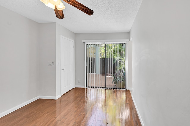 empty room with hardwood / wood-style flooring, ceiling fan, and a textured ceiling