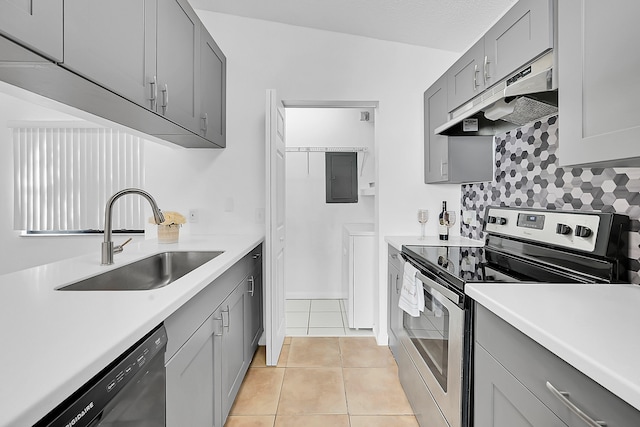 kitchen featuring dishwasher, sink, stainless steel range with electric cooktop, lofted ceiling, and light tile patterned floors