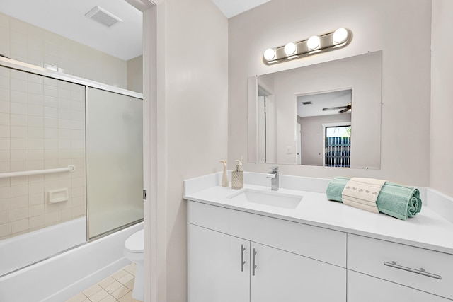 full bathroom featuring vanity, tile patterned floors, bath / shower combo with glass door, ceiling fan, and toilet