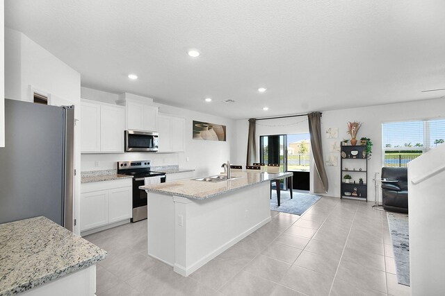 kitchen featuring white cabinetry, plenty of natural light, a kitchen island with sink, and appliances with stainless steel finishes