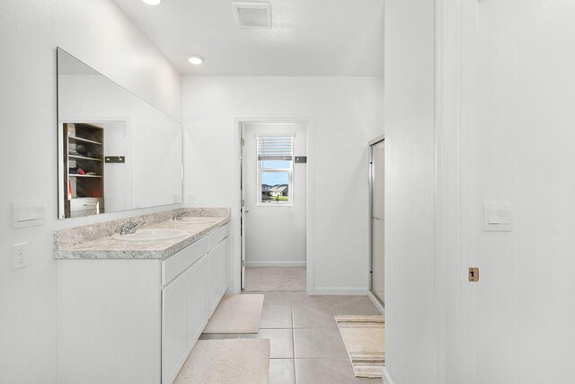 bathroom featuring vanity, tile patterned floors, and a shower with door