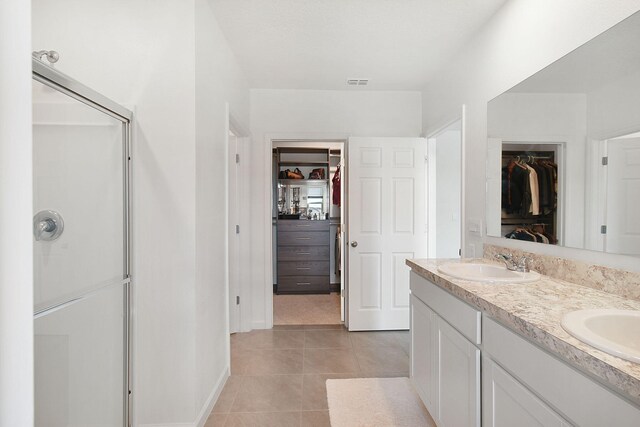 bathroom with tile patterned flooring, vanity, and a shower with shower door