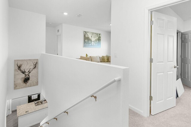 stairs with carpet and sink