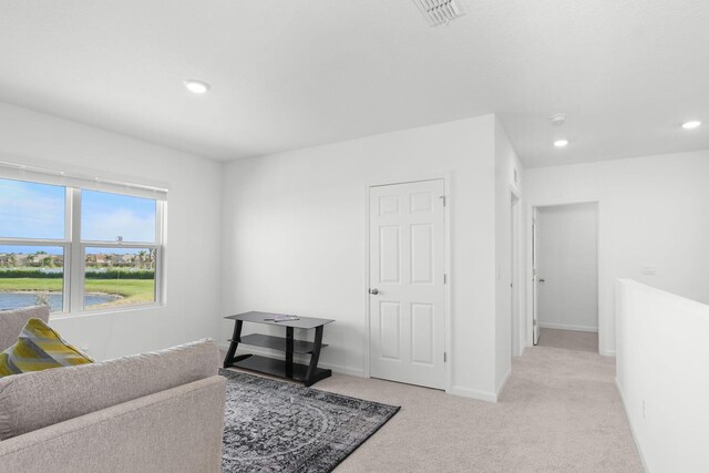 sitting room featuring light carpet