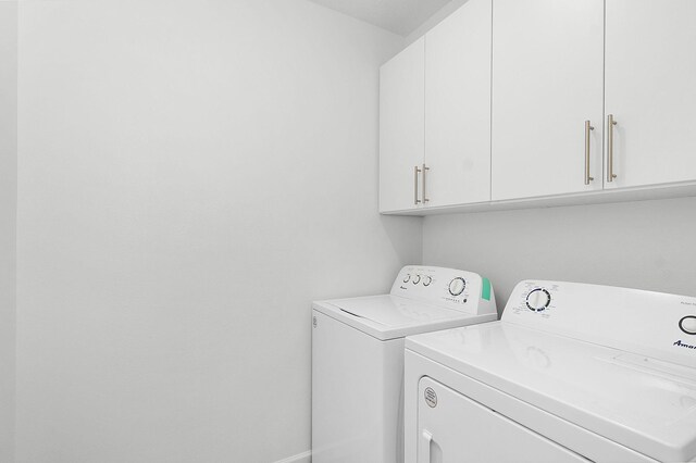 washroom with cabinets and washing machine and clothes dryer