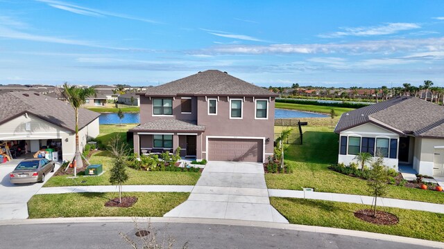 view of front of house with a water view, a front yard, and a garage