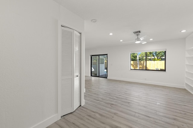 spare room featuring light wood-type flooring and ceiling fan